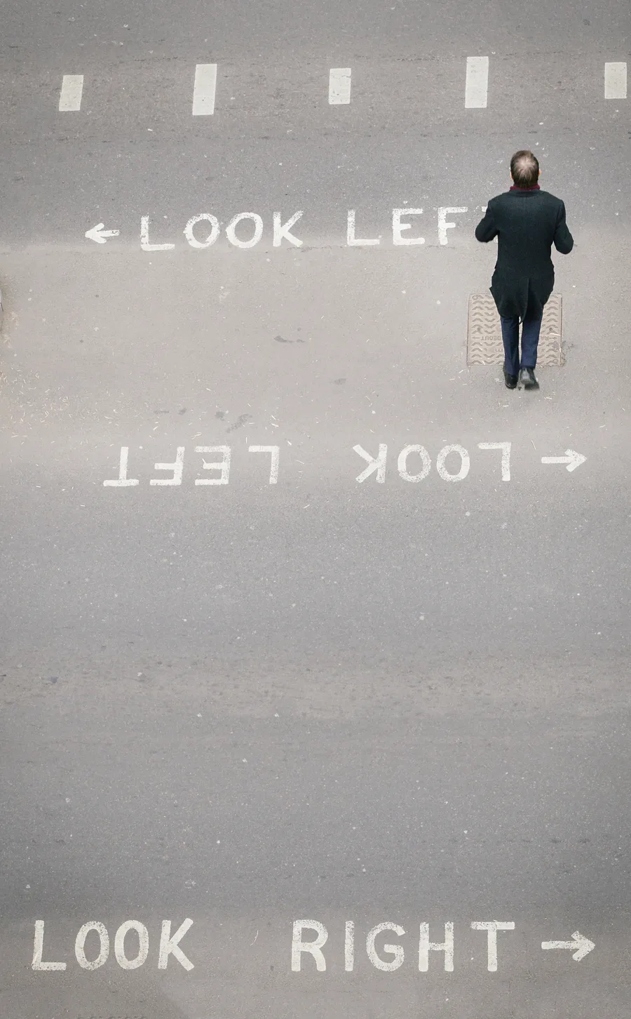 Aerial view of a man crossing a road marked Look Left and Look Right