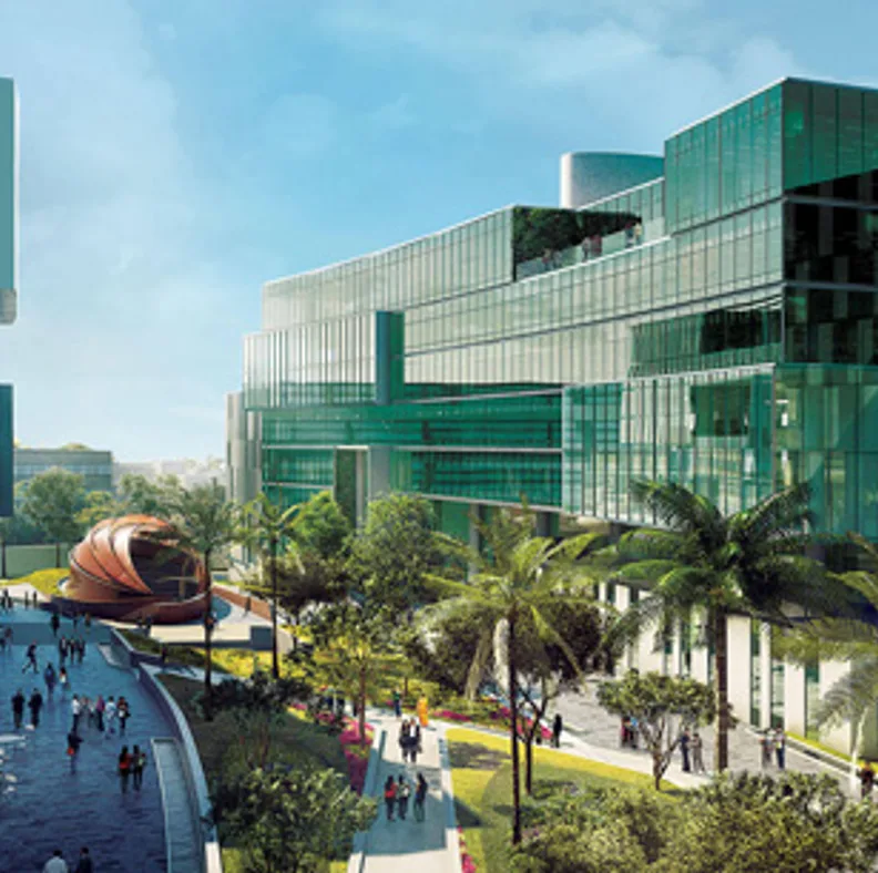 Bangalore tech campus with green glass buildings, palm trees and a landscaped walkway