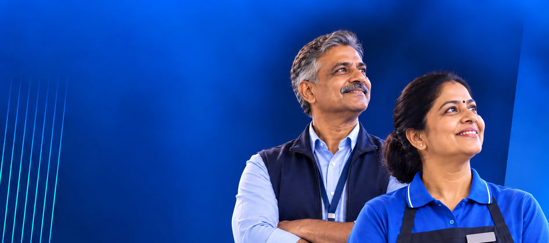 Store manager and retail associate smiling and looking ahead against a blue background